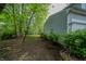 Backyard with side view of house, surrounded by mature trees and bushes at 1334 Legacy Ct, Indianapolis, IN 46234