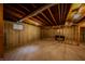 Unfinished basement with exposed beams and concrete walls offers potential for customization, with a foosball table at 1334 Legacy Ct, Indianapolis, IN 46234