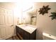 Modern bathroom with a dark vanity, white countertop, and decorative wall art at 1334 Legacy Ct, Indianapolis, IN 46234
