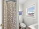 Bathroom featuring a shower, toilet, and sink with a window at 1391 N Shadeland Ave, Indianapolis, IN 46219