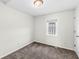 Bedroom with neutral carpet, white walls, and a window with decorative bars at 1391 N Shadeland Ave, Indianapolis, IN 46219