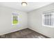 Bedroom with neutral carpet, white walls, and two windows with decorative bars at 1391 N Shadeland Ave, Indianapolis, IN 46219