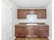 A well-lit kitchen featuring wood cabinets, a sink, and tile backsplash at 1391 N Shadeland Ave, Indianapolis, IN 46219