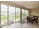 Sunlit dining area with sliding glass doors to the backyard and neutral tile flooring at 14018 Powder Dr, Carmel, IN 46033