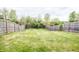 Large backyard showcasing a well-maintained lawn surrounded by a wooden fence and lush greenery at 1404 Norton Dr, Greenwood, IN 46143