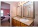 Bathroom boasting a double vanity, framed mirrors, and a glimpse into an adjacent bedroom at 1404 Norton Dr, Greenwood, IN 46143