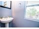 Powder room showcasing a sleek pedestal sink and a window with natural light at 1404 Norton Dr, Greenwood, IN 46143