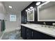 Modern bathroom boasting a walk-in shower, dual sink vanity with marble countertop, and unique tile flooring at 1601 E Edwards Ave, Indianapolis, IN 46227