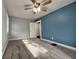 Sunny bedroom with carpet, ceiling fan, blue accent wall, and large windows for natural light at 1601 E Edwards Ave, Indianapolis, IN 46227