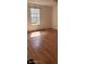 A bright bedroom featuring new, light-colored laminate wood flooring and a window at 1632 W 8Th W St, Anderson, IN 46016