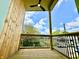 Relaxing balcony with wood floors, wood paneling, and black metal railings overlooking a bright, neighborhood at 1721 Thaddeus St, Indianapolis, IN 46203