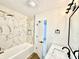 Modern bathroom featuring a soaking tub, marble-style tile, and updated lighting fixtures at 1721 Thaddeus St, Indianapolis, IN 46203