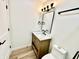 A stylish bathroom featuring a wood vanity, marble countertop, and black hardware at 1721 Thaddeus St, Indianapolis, IN 46203