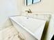Modern white bathtub features a gold faucet and sleek design with marble flooring at 1721 Thaddeus St, Indianapolis, IN 46203