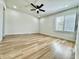 Minimalist bedroom features a ceiling fan, light-colored flooring, and a large window with blinds at 1721 Thaddeus St, Indianapolis, IN 46203