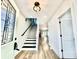 Bright foyer with modern staircase, decorative lighting, and hardwood floors at 1721 Thaddeus St, Indianapolis, IN 46203