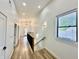 Bright hallway featuring wood floors, modern lighting, and window with natural light streaming in at 1721 Thaddeus St, Indianapolis, IN 46203