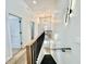 Hallway with wood floors leads to a staircase with modern railings and contemporary lighting at 1721 Thaddeus St, Indianapolis, IN 46203