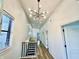 Hallway with modern lighting, a staircase featuring black railings, and ample natural light from windows at 1721 Thaddeus St, Indianapolis, IN 46203