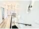 Hallway with wood floors leading to staircase, showcasing modern lighting and design elements at 1721 Thaddeus St, Indianapolis, IN 46203