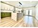 Open concept kitchen features modern appliances, white and green cabinets, and a central island with a marble countertop at 1721 Thaddeus St, Indianapolis, IN 46203