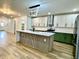 Spacious kitchen featuring modern lighting, white and green cabinetry, stainless steel appliances, and marble countertops at 1721 Thaddeus St, Indianapolis, IN 46203