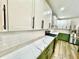 Bright kitchen with white subway tile backsplash, marble countertops, stainless steel appliances, and green lower cabinets at 1721 Thaddeus St, Indianapolis, IN 46203