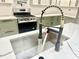 Modern kitchen sink with white countertops, stainless steel basin, and matte black faucet with flexible hose at 1721 Thaddeus St, Indianapolis, IN 46203