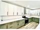 Well-lit kitchen with modern green lower cabinets and stainless steel appliances at 1721 Thaddeus St, Indianapolis, IN 46203