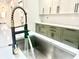 Close-up of a modern kitchen sink with a brushed gold faucet and white countertops at 1721 Thaddeus St, Indianapolis, IN 46203