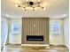 Modern living room with electric fireplace, stylish light fixture, and plank accent wall at 1721 Thaddeus St, Indianapolis, IN 46203