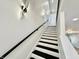 Elegant staircase with black and white steps, accented by modern wall sconces at 1721 Thaddeus St, Indianapolis, IN 46203