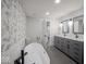 Modern bathroom featuring a soaking tub, gray cabinets, and stylish floral wallpaper accent wall at 1737 W 1000 N, Alexandria, IN 46001