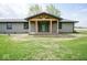 A covered front entrance with a quaint porch, gray siding and green front door at 1737 W 1000 N, Alexandria, IN 46001