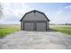 This stylish garage has a contrasting trim against its gray siding with two garage doors at 1737 W 1000 N, Alexandria, IN 46001