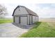 Well-kept garage with a barn roof line and gray siding complemented by a long driveway at 1737 W 1000 N, Alexandria, IN 46001