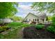 Lush backyard featuring a large lawn, a patio with seating, and beautiful landscaping, creating a serene outdoor space at 19519 Creekview Dr, Noblesville, IN 46062