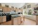 Well-lit kitchen boasts wood floors, ample wood cabinets, black appliances, and green countertops at 19519 Creekview Dr, Noblesville, IN 46062