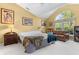 Sun-filled main bedroom with tan walls, a large window, and a sitting area with a leather couch at 19519 Creekview Dr, Noblesville, IN 46062