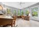 Bright sunroom with lots of windows, tile flooring, ceiling fan, and lots of space for relaxing and entertaining guests at 19519 Creekview Dr, Noblesville, IN 46062