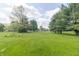 Lush green backyard with mature trees providing ample shade and a sense of privacy and seclusion at 2237 W 100 N, Greenfield, IN 46140