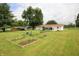 Large backyard with lush lawn, a garden, and an enclosed sunroom at 2237 W 100 N, Greenfield, IN 46140