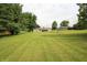 Expansive backyard showcasing mature trees and lush greenery surrounding the home at 2237 W 100 N, Greenfield, IN 46140