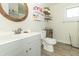 Clean bathroom with a grey vanity, wood-look floors, and open shelving offering a modern and functional design at 2237 W 100 N, Greenfield, IN 46140