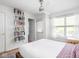 Bright bedroom featuring a ceiling fan, hardwood floors, and a wall of books at 2403 N Delaware St, Indianapolis, IN 46205