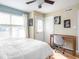 Bright bedroom with a ceiling fan, a wooden desk, and an exit door with wooden floors throughout at 2403 N Delaware St, Indianapolis, IN 46205