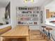 Dining area with a large wooden table, built-in bookshelves, and an open view to the kitchen at 2403 N Delaware St, Indianapolis, IN 46205