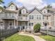 Exterior of townhouse with multiple balconies, a patio, green space, and wood fence at 2403 N Delaware St, Indianapolis, IN 46205