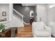 Bright living room with hardwood floors, stairs, and a decorative mirror at 2403 N Delaware St, Indianapolis, IN 46205