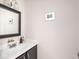 The powder room has a dark framed mirror, a small sink, and soft paint at 2403 N Delaware St, Indianapolis, IN 46205